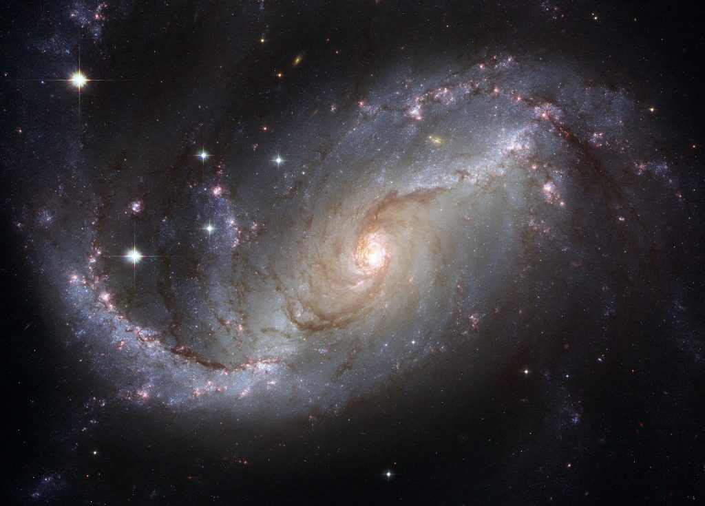 From the Hubble telescope: Image of galaxy NGC 1672. Shown are star-forming clouds and dark bands of interstellar dust, which may or may not be loaded with PQQ. By NASA, ESA, and The Hubble Heritage Team (STScI/AURA)-ESA/Hubble Collaboration [Public domain], via Wikimedia Commons